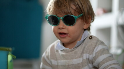 Toddler wearing sunglasses, cool looking baby boy