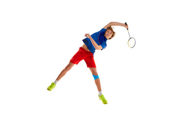 Fototapeta na wymiar Portrait of teen boy in uniform playing badminton, training isolated over white background. In a jump, serving
