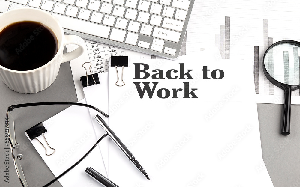 Aufkleber back to work text on a paper with magnifier, coffee and keyboard on grey background