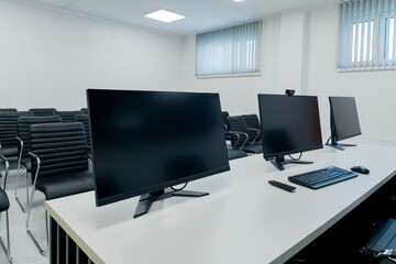 Modern high-tech office with desktop PCs and computer monitors for video conferencing via Internet, remote meetings and presentations