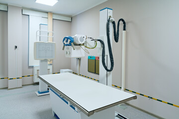 Modern radiology room with fluorography scanning equipment and empty bed for X-ray diagnostic and healthcare exam of patients in hospital