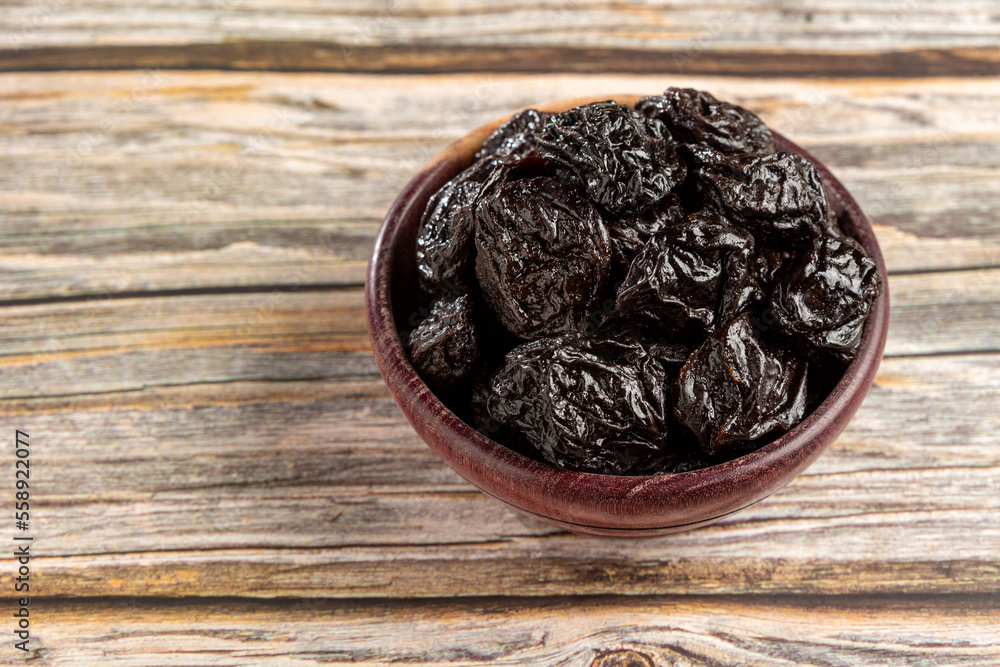 Wall mural bowl with prunes on the table.