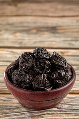 Bowl with prunes on the table.