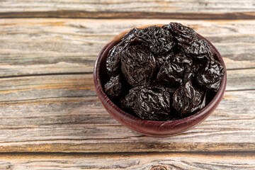 Bowl with prunes on the table.