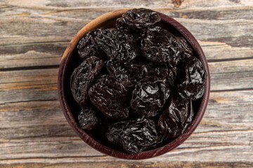 Bowl with prunes on the table.
