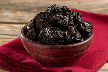 Bowl with prunes on the table.