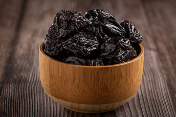 Bowl with prunes on the table.
