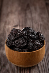 Bowl with prunes on the table.