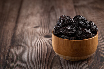 Bowl with prunes on the table.