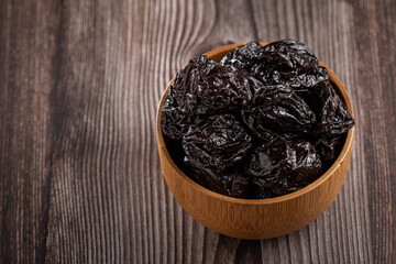 Bowl with prunes on the table.