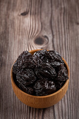 Bowl with prunes on the table.