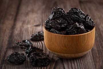 Bowl with prunes on the table.
