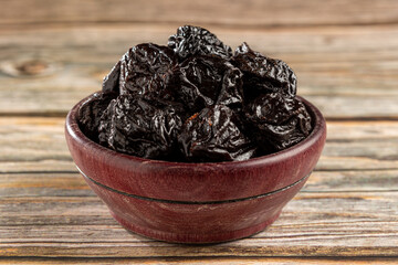 Bowl with prunes on the table.