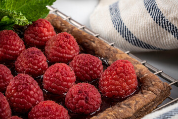 raspberry tart on chocolate puff pastry garnished with mint leaves
.