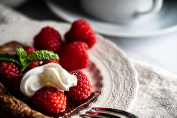 raspberry tart on chocolate puff pastry garnished with mint leaves
.