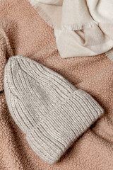 Fototapeta na wymiar Winter hat lies on a textured plain background. Clothes top view