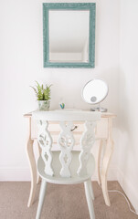 Mirror above old fashioned table and chairs, white country cottage style