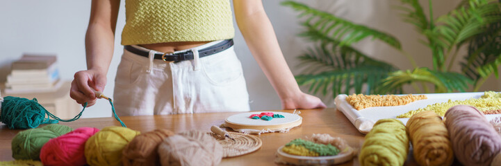 Needlework concept, Women holding punch needle with yarn to embroidery on canvas in wood hoop © snowing12
