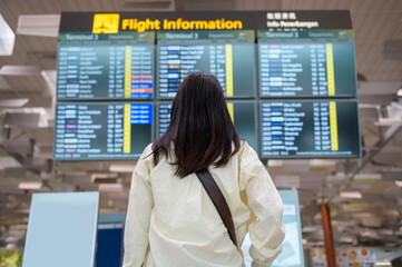 A traveller woman is wearing protective mask in International airport, travel under Covid-19 pandemic, safety travels, social distancing protocol, New normal travel concept