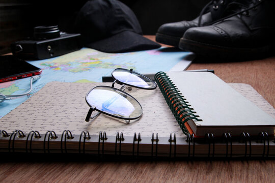 Travel equipment lies on a wooden table. 
