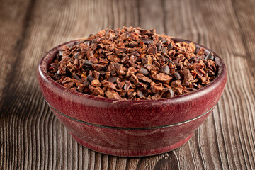Bowl with cocoa nibs on the table.