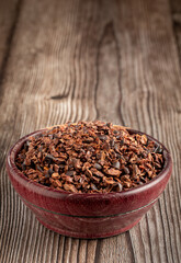 Bowl with cocoa nibs on the table.