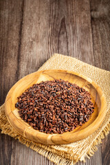 Cocoa nibs on wooden plate.