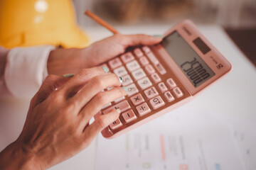 Close-up photo of woman hands doing calculating Bill with calculator financial planning and checking receipts at home office