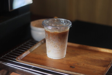 Closeup of Iced Caramel Macchiato at the coffee shop, Caramel Macchiato is a classic macchiato beverage. It consists of vanilla syrup, espresso, steamed milk, foam, and caramel drizzle