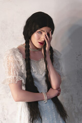 Young girl with dark hair in a white vintage dress from the 19th century. Studio shooting