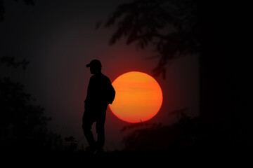 Fototapeta premium Silhouette of a person standing against a large sunset