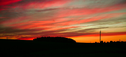 Sky After sunset - background. Panorama colorful magnificent sunset in countryside above hills and...