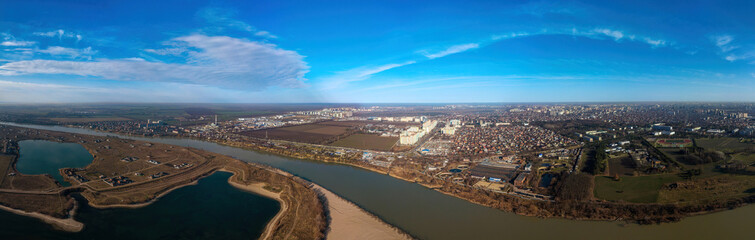 aerial landscape of the Kuban plain - a bend of the river, a lake and the outskirts of the city of Koasnodar on a sunny winter day - obrazy, fototapety, plakaty
