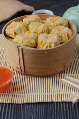 siomay dimsum filled with prawns, chicken, spring onions, on black background