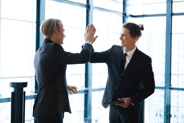 businessman giving hi five pose for success at work with friends and having fun in the office