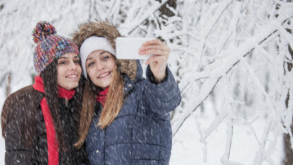 Happy couple taking selfie while snowing