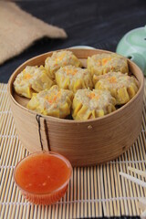 siomay dimsum filled with prawns, chicken, spring onions, on black background