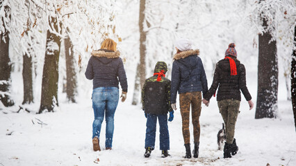 Fototapeta na wymiar Mother with her grown up children walking on snow