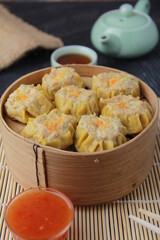 siomay dimsum filled with prawns, chicken, spring onions, on black background