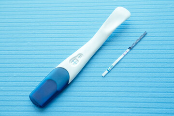 Positive pregnancy test with two strips. Blue color background. Positive result. Close-up