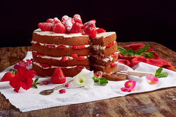 Victoria sponge cake with cream and strawberry on table with flower decor. Copy space