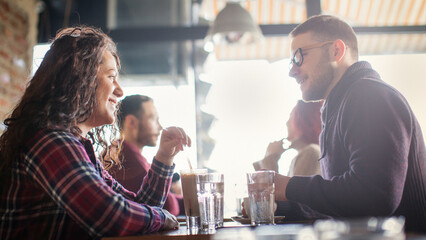 A couple in love are enjoying themselves in the cafe drinking coffee