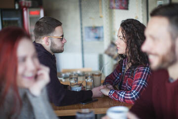 A couple in love are enjoying themselves in the cafe drinking coffee