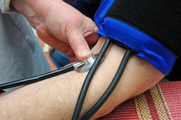 Paramedic hand taking blood pressure and heart rates by tonometer from a patient