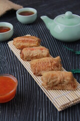 Dimsum, as the name Keicak, is filled with carrots, chicken, mushrooms and wrapped in tofu skin, side angle with black background