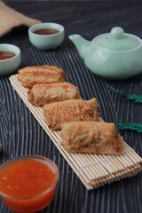 Dimsum, as the name Keicak, is filled with carrots, chicken, mushrooms and wrapped in tofu skin, side angle with black background