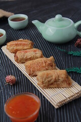 Dimsum, as the name Keicak, is filled with carrots, chicken, mushrooms and wrapped in tofu skin, side angle with black background