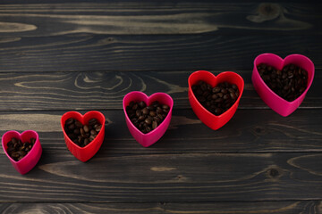 fragrant rich coffee beans of different varieties on a dark wooden surface are laid out in the form of a heart. for banners, flyers, splash screens, menu labels