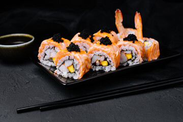 Sushi roll with fried salmon, shrimp and black caviar