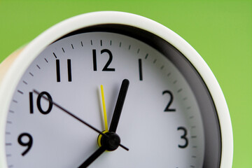 Naklejka na ściany i meble Alarm clock on green background, time concept, clock photo